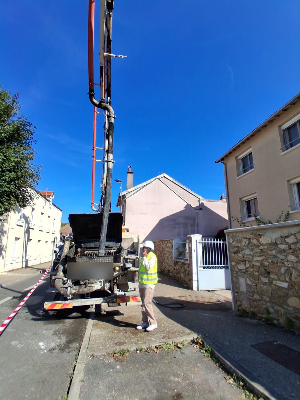 Chef de chantier ÉDF près du camion-pompe à béton